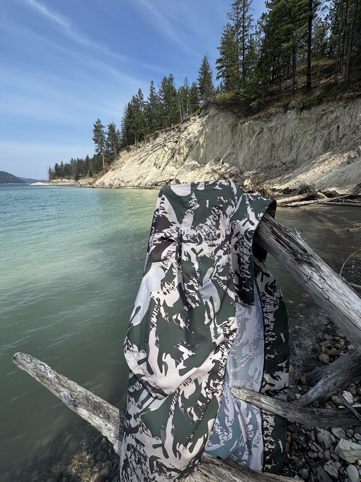 KTT camouflage draped over driftwood beside Lake Koocanusa