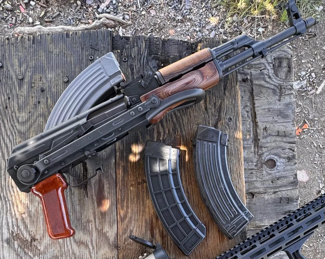 1984 Polish AKM and magazines on an outdoor wooden bench