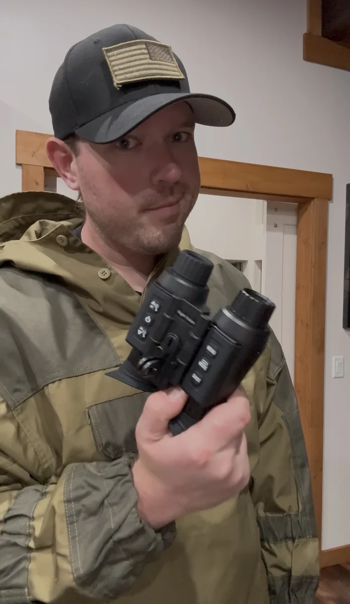 Cody Rhoads holding two night-observation devices during a documentation session
